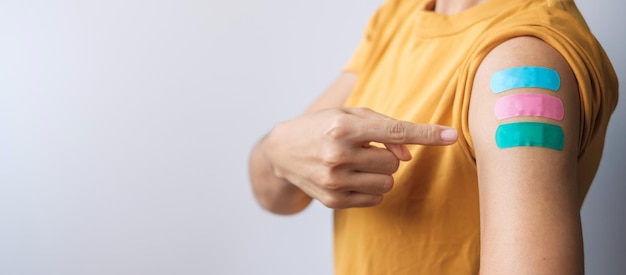 Woman showing plaster after receiving covid 19 vaccine. Vaccination, herd immunity, side effect, booster dose, vaccine passport and Coronavirus pandemic