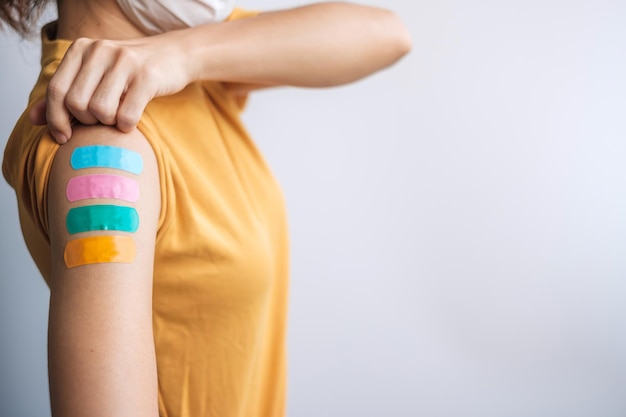 Woman showing plaster after receiving covid 19 vaccine. Vaccination, herd immunity, side effect, booster dose, vaccine passport and Coronavirus pandemic