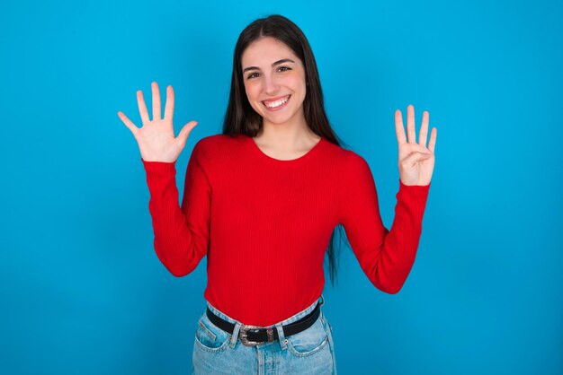 Woman showing and pointing up with fingers number nine while smiling confident and happy