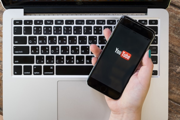 Donna che mostra la schermata di youtube su smartphone