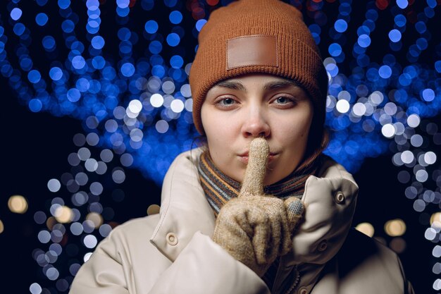 woman showing secret gesture and touching lips with index finger