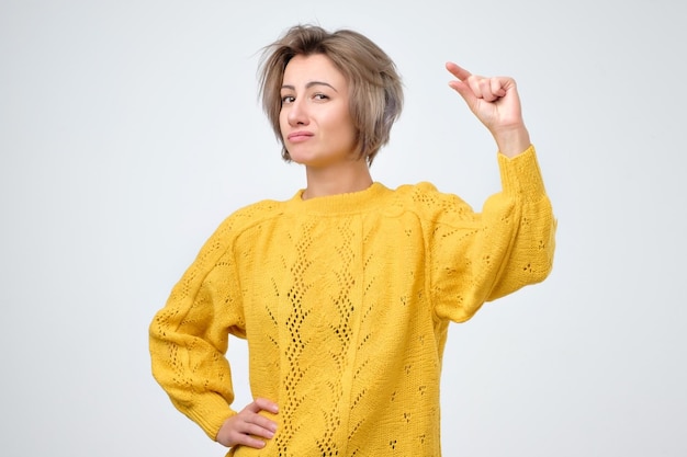 Woman showing small amount of something with fingers