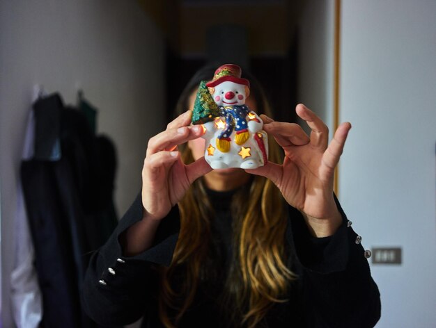 Photo woman showing snowman figurine