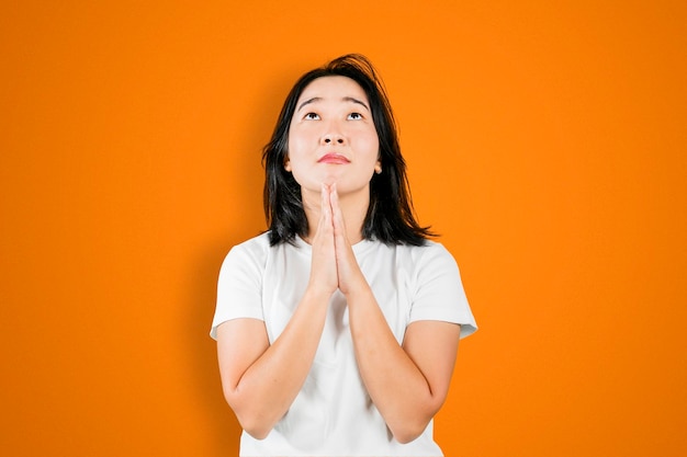 Woman showing supplication hands gesture on studio