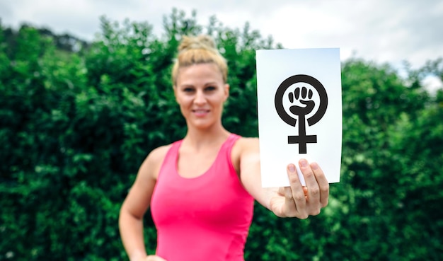 Женщина показывает символ феминизма