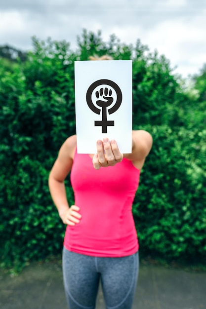 Foto donna che mostra il simbolo del femminismo