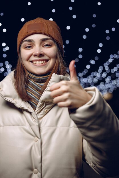 親指を立てたり、いいねのジェスチャーをしたり、カメラを見たりする女性