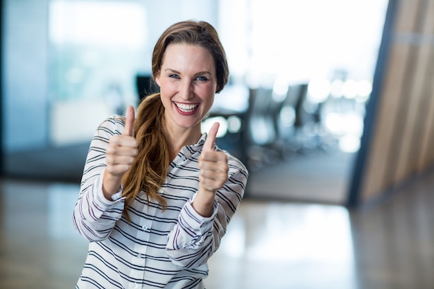 写真 オフィスで親指を現して女性