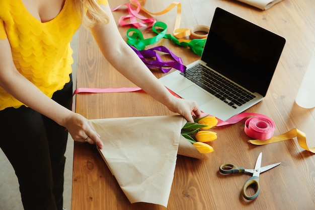 Woman shows how to make bouquet with tulips