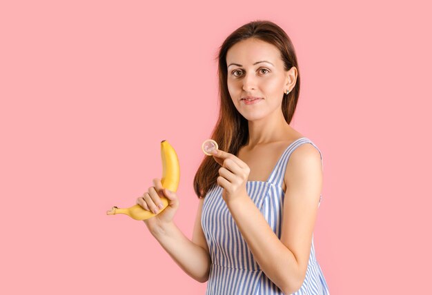 Premium Photo A woman shows how to put a condom on a banana picture