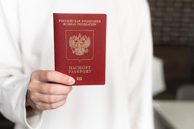 Photo woman shows a passport female hands close-up background blur