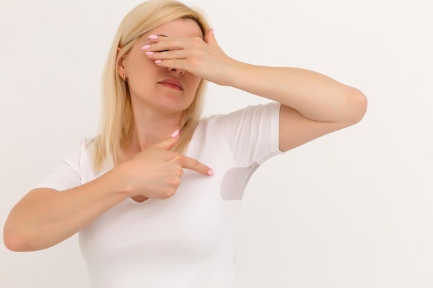 woman shows a spot on her white t-shirt