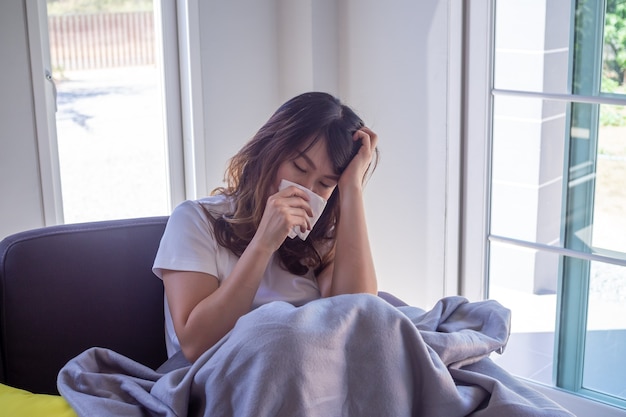 Woman sick on the sofa in the house women have headaches