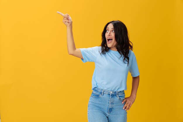 Woman signal smile with teeth emotion portrait in blue t-shirt on yellow background hands up