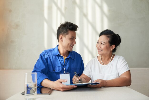 Woman signing contract with handyman