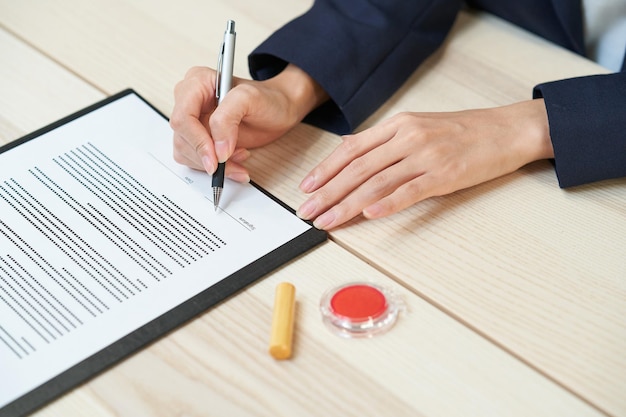 Woman signing documents on the desk