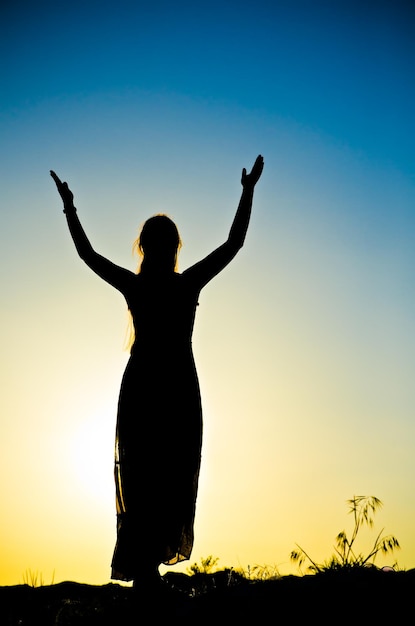 Woman silhouette in front of a sunset