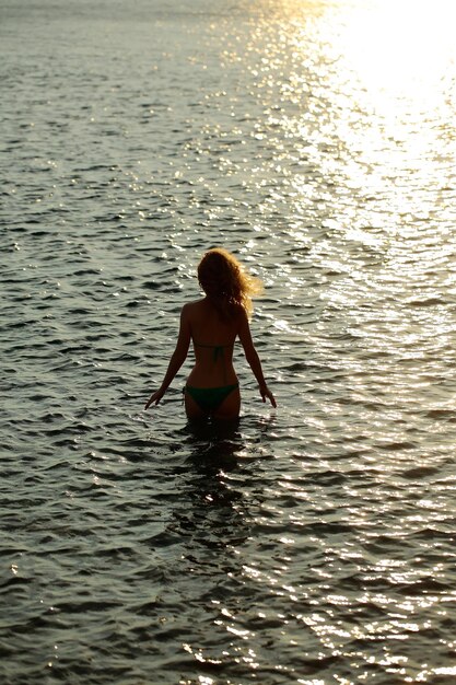 Woman silhouette in sunset beach