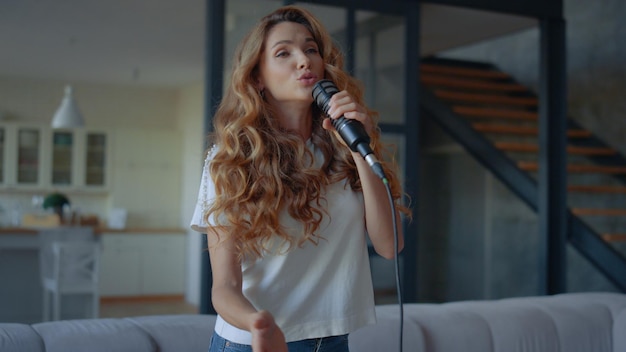 Женщина поет песню в профессиональный микрофон Певица разучивает новую песню