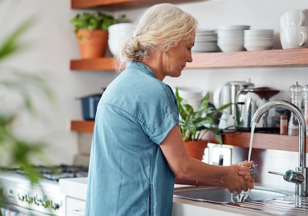 Woman sink and kitchen for hands for washing hygiene and water for clean in home Sanitation disinfection and safety from germs and virus for mature person wellness and cleaning of bacteria