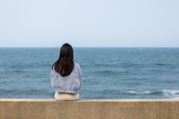 Woman sit beside the waterfront in Taiwan