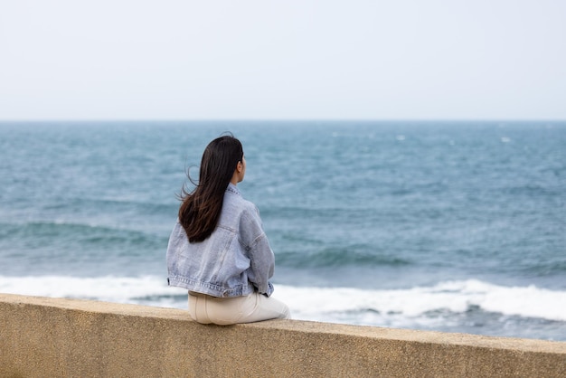 Woman sit beside the waterfront in Taiwan