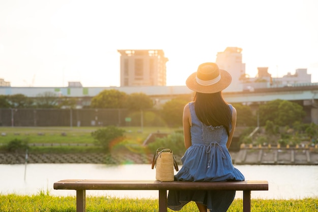 Woman sit on the chair at riverside under the sunlight