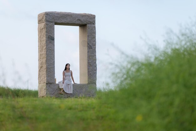 Woman sit on the rock stone and look around the view