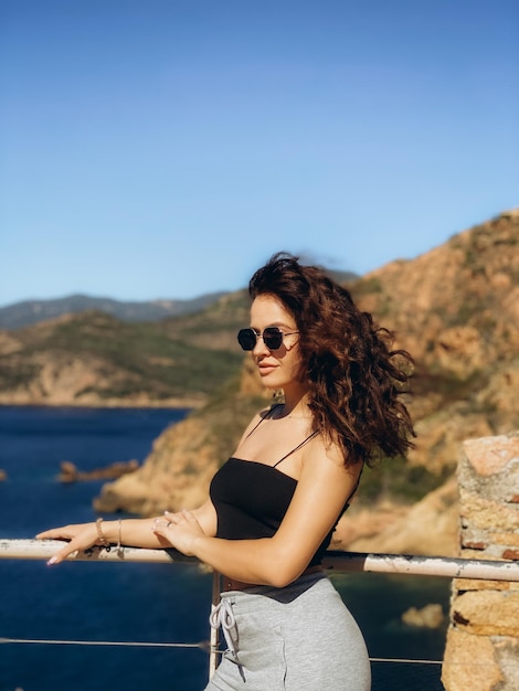 Woman sit on a wall looking at the view in Corsica High quality photo