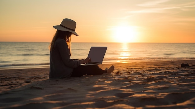 A woman sits on a beach with a laptop in front of her.