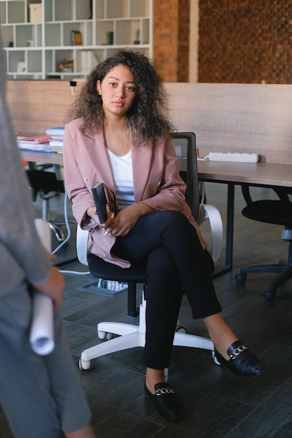 a woman sits in a chair with a book in her hand