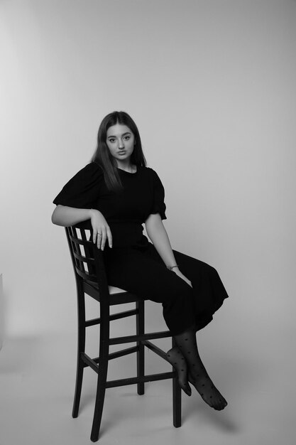 a woman sits in a chair with her arms crossed