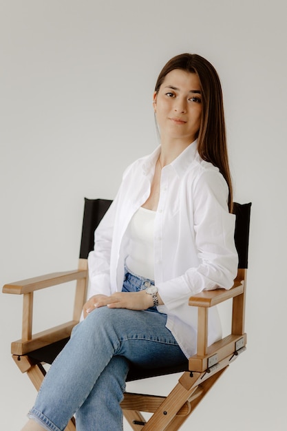 Photo a woman sits in a chair with her hands on her hips