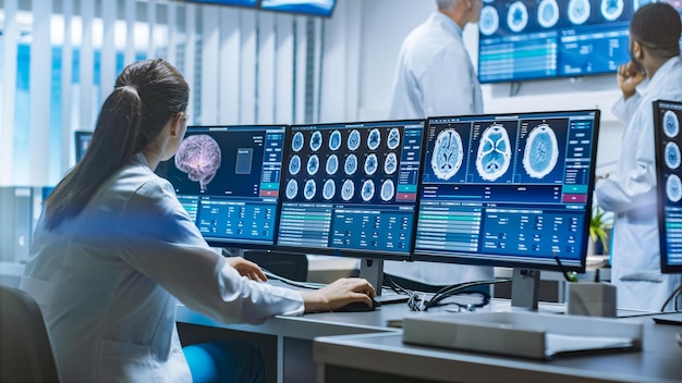 A woman sits at a desk with a brain display.