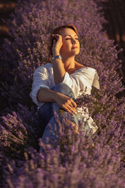 Photo a woman sits in a field of lavender