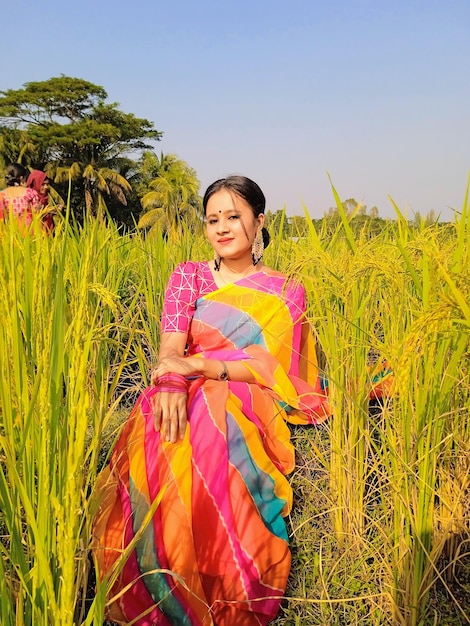 Photo a woman sits in a field of rice.