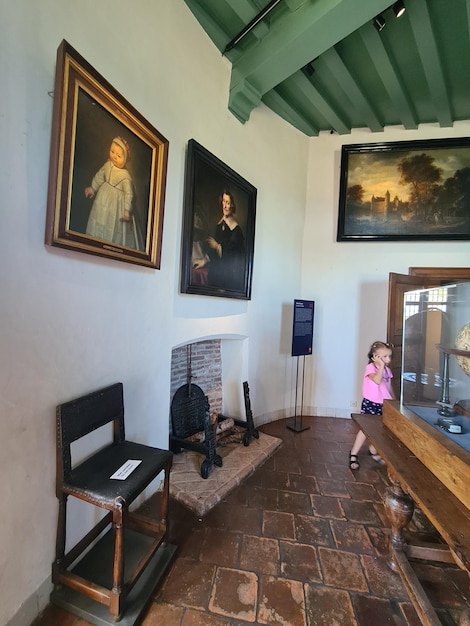 a woman sits in front of two paintings that say " mother ".