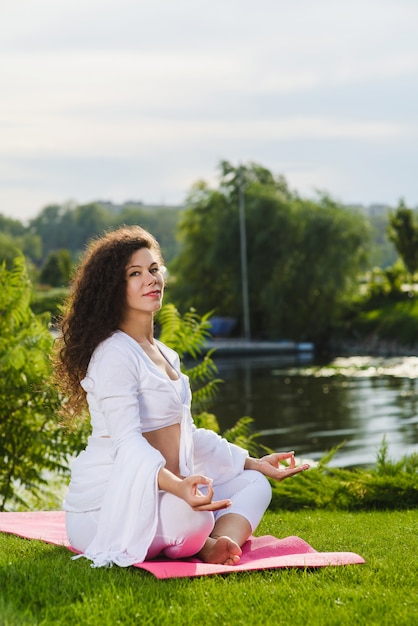 Woman sits in lotus position.