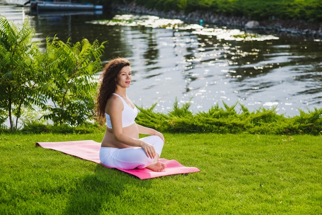 Woman sits in lotus position.