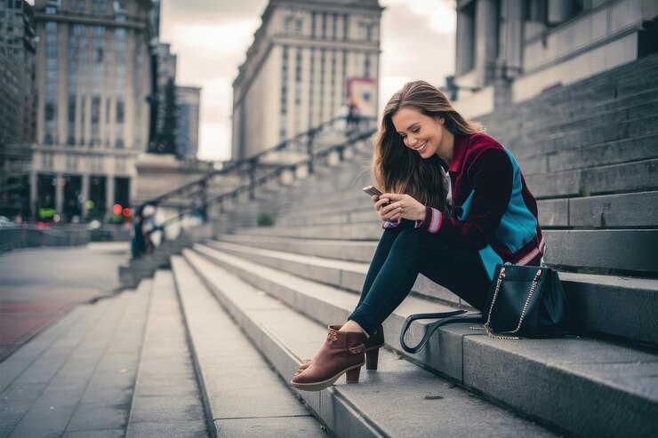 Photo a woman sits on the steps with a cell phone