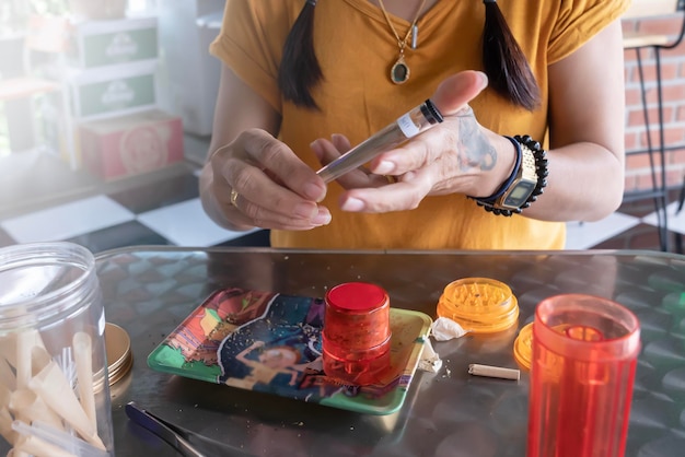 A woman sits at a table with a cup of tea and a phone.