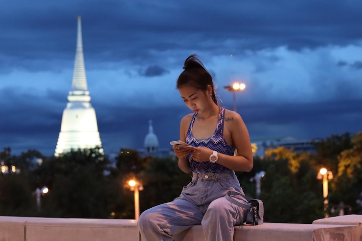 Photo 夜に照らされた街の向こうに座っている女性