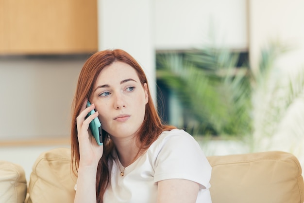 woman sitting alone at home on the couch, feeling pain and depression 