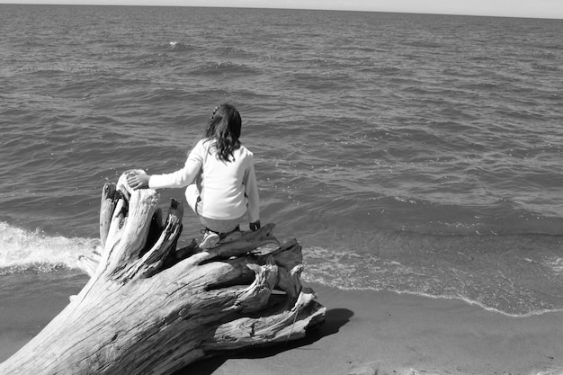 Фото Женщина сидит на берегу моря