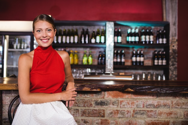 Woman sitting at bar counter in bar