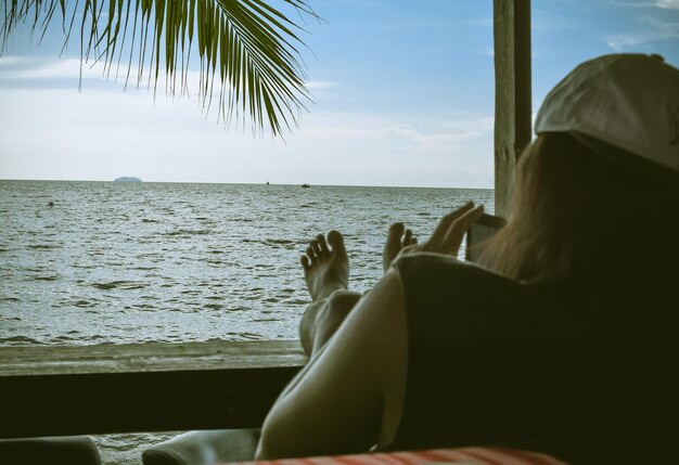 Woman sitting on beach against sky