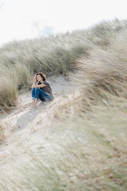 Woman sitting in beach dune