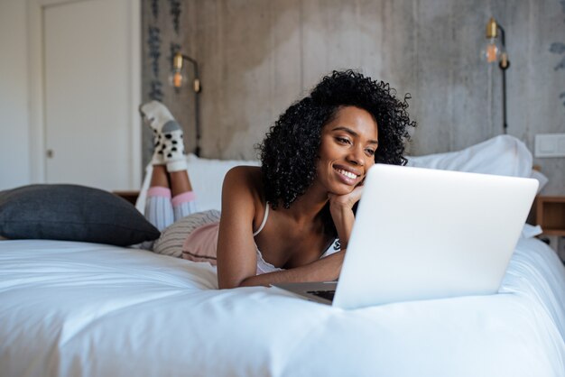 Woman sitting on bed on the computer