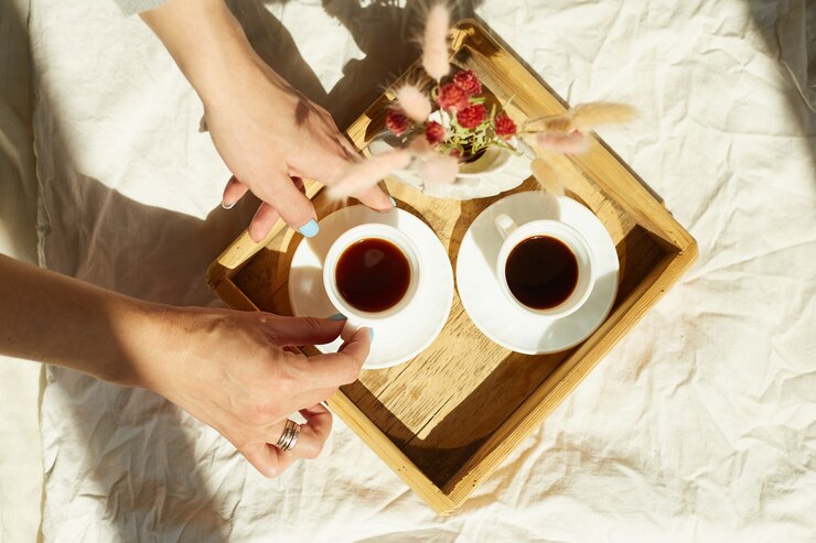 Photo woman sitting on the bed, and drink coffee during the morning sunlight, breakfast in the bed.