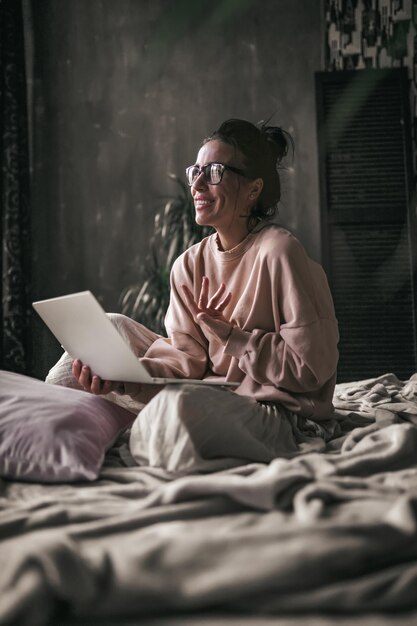 Photo woman sitting on bed at home